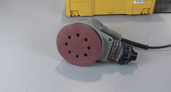 A random orbit sander with eight holes in the pad and the pad protector