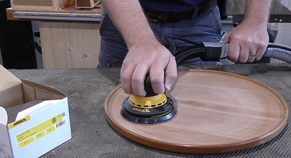 A random orbit sander being used on wood