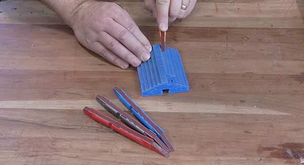 A worker sands a small plastic 3D model using a 2Sand Sanding Detailer Stick