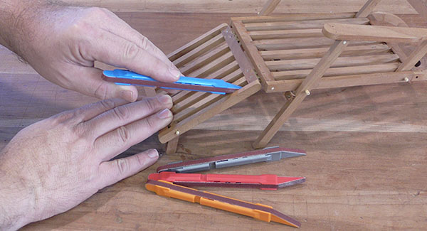 A craftsperson sands a small wooden model with 2Sand Sanding Detailer Sticks