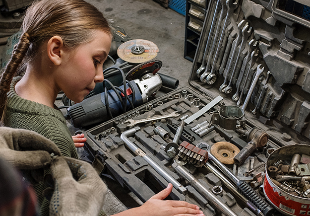 A girl looks at wrenches and grinding tools. Photo by CottonBro on Pexels.com