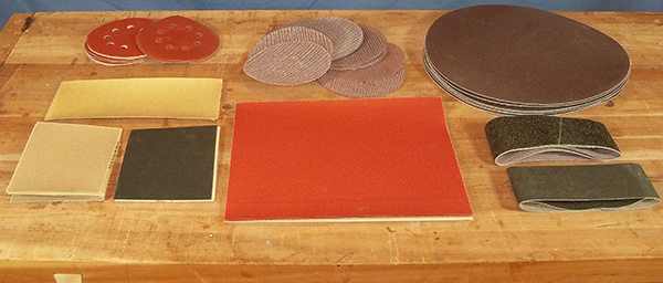 A variety of sandpaper sheets including sanding discs and sanding belts